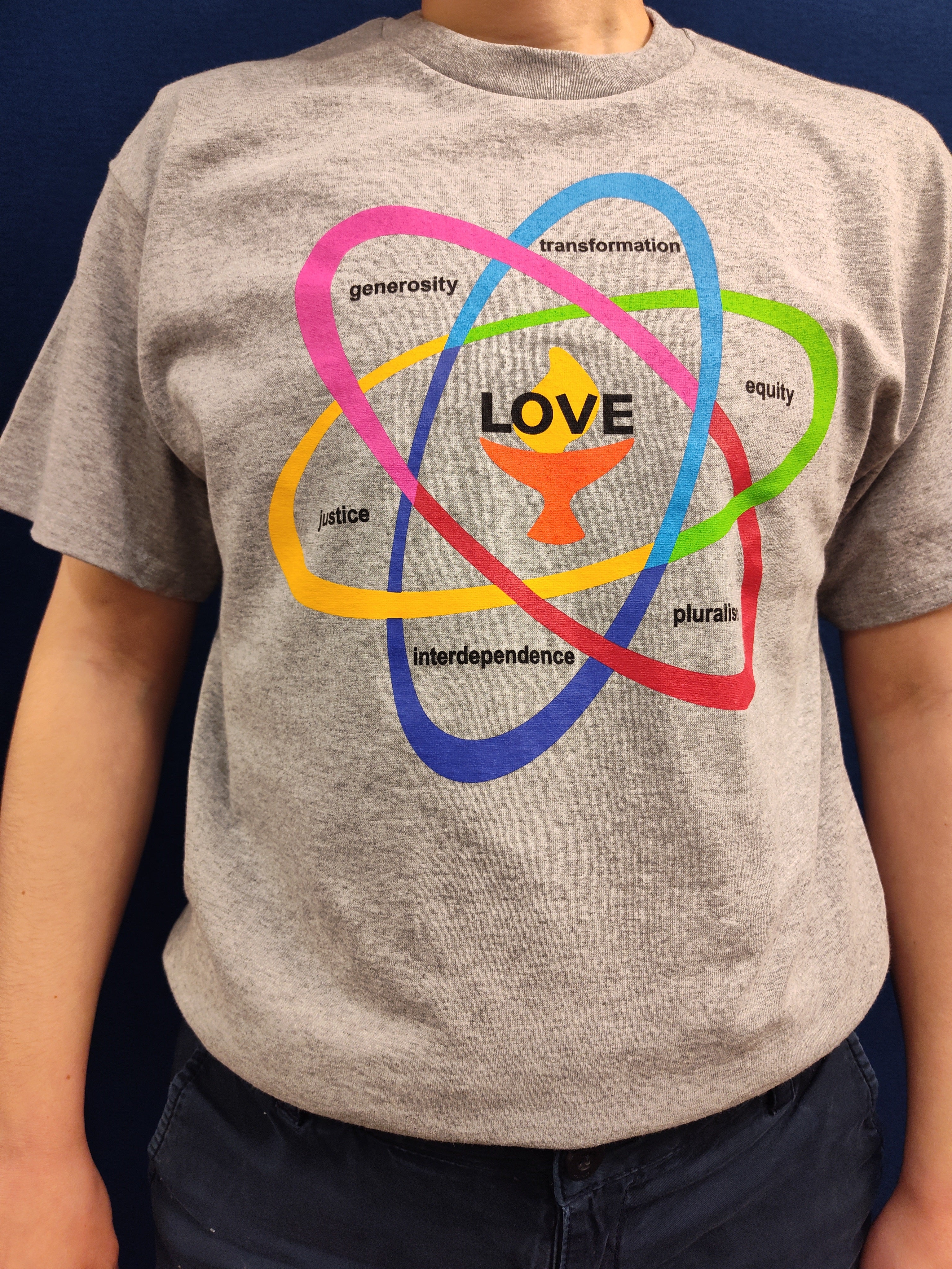 image of person wearing gray UU Shared Values T Shirt with multi-colored atom design