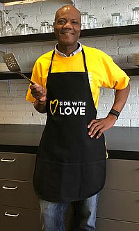 image of man wearing Side With Love black apron