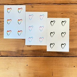 image of 3 packs of Side with Love Stickers; rainbow, trans colors, and forest green hearts