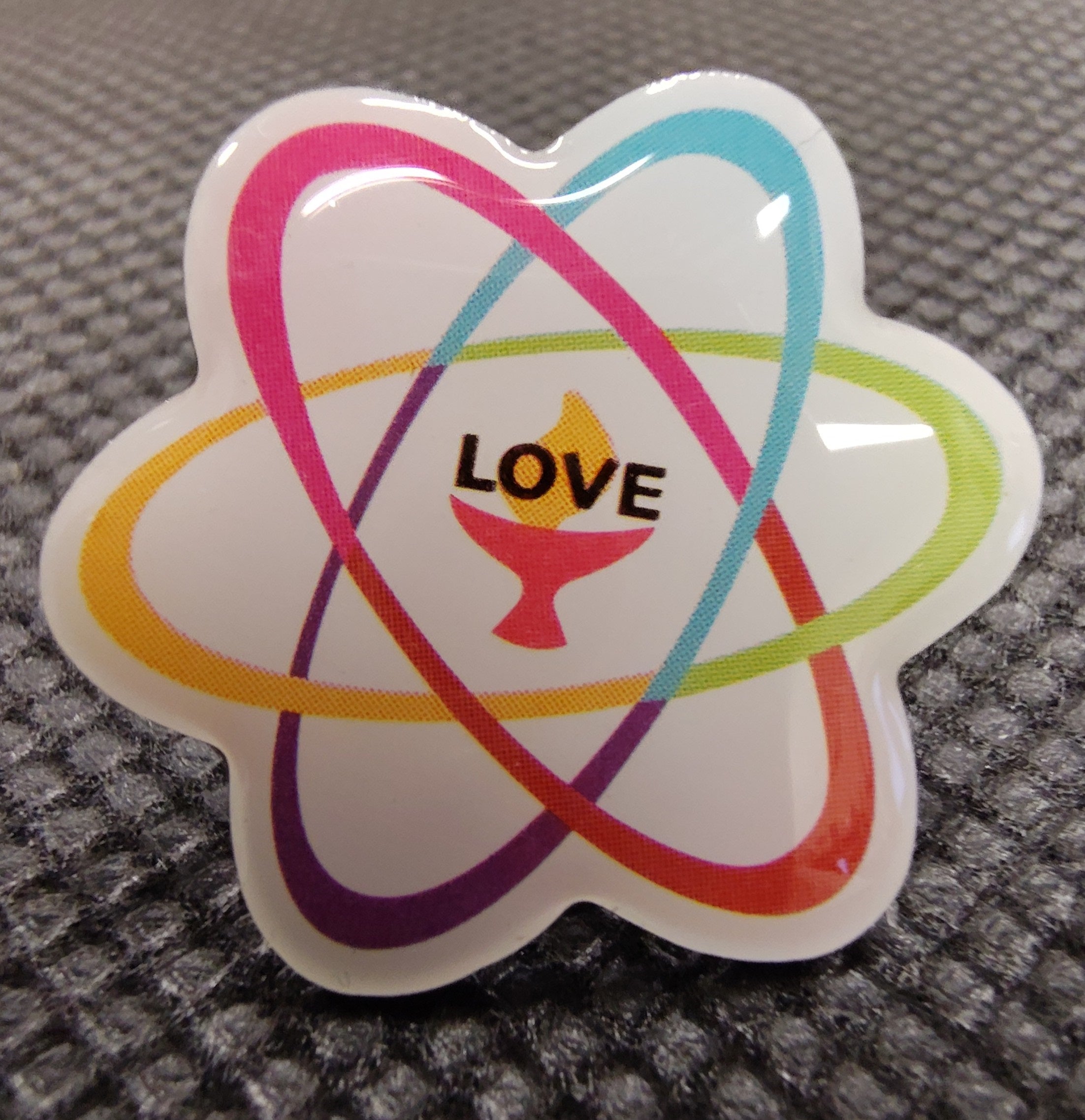 image of UU Shared Values Enamel pin with colorful atom design