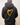 Person wearing a black hoodie with a yellow heart design on the back against a plain background